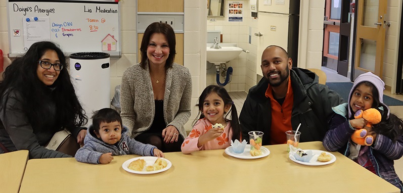 VP of Operations Rosemary Stiglic sits with a PLASP family for a group photo